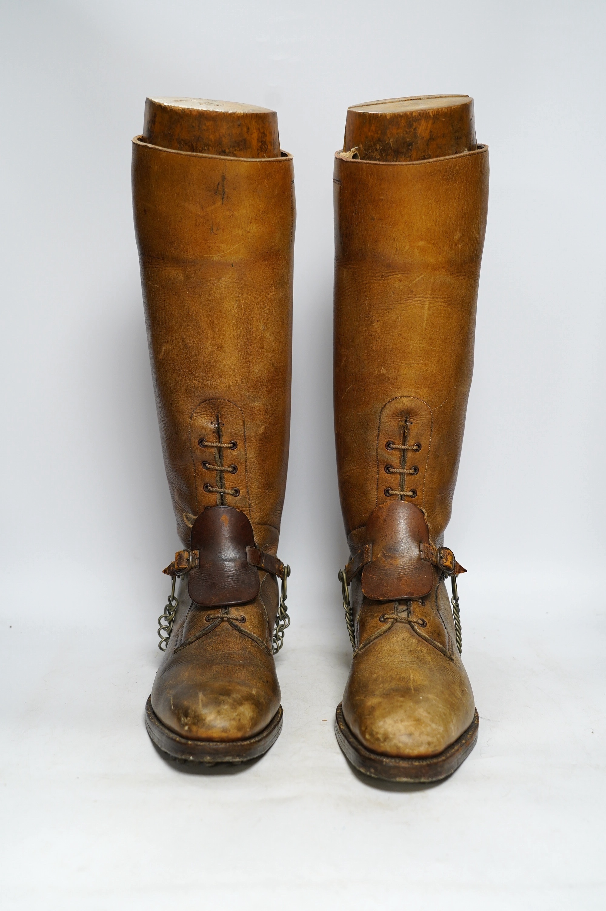 A pair of military First World War boots in tan leather, hobnail soles, two-part wooden shoe trees, and spurs. Condition - fair to good, some rubbing, fading and staining to the leather